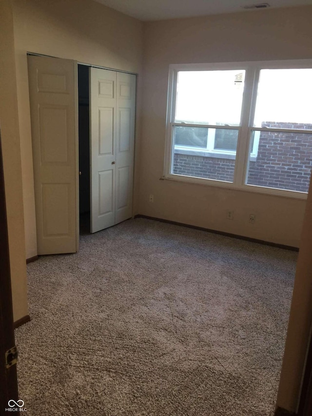 unfurnished bedroom with carpet and a closet