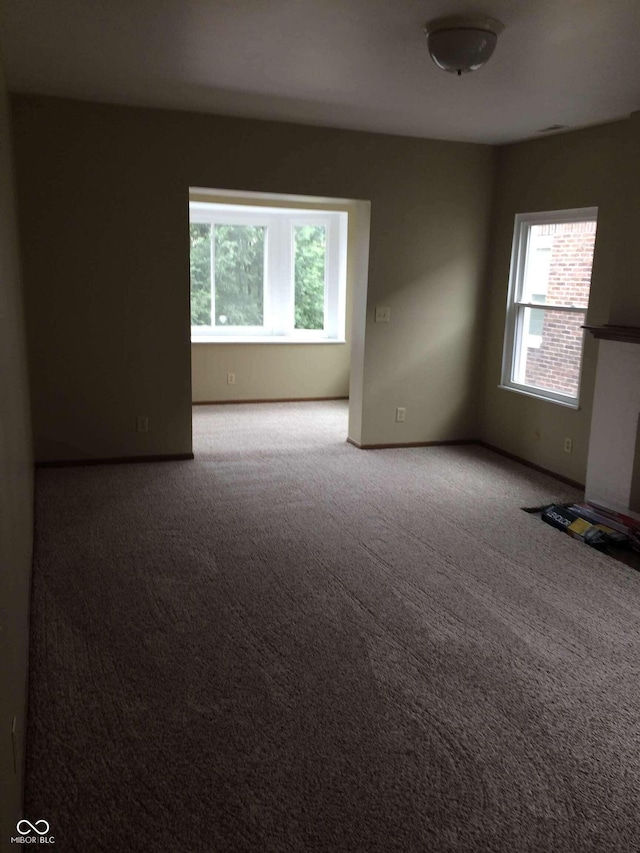 carpeted spare room featuring a healthy amount of sunlight