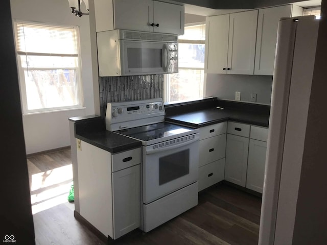 kitchen featuring dark wood-type flooring, white cabinets, and white appliances