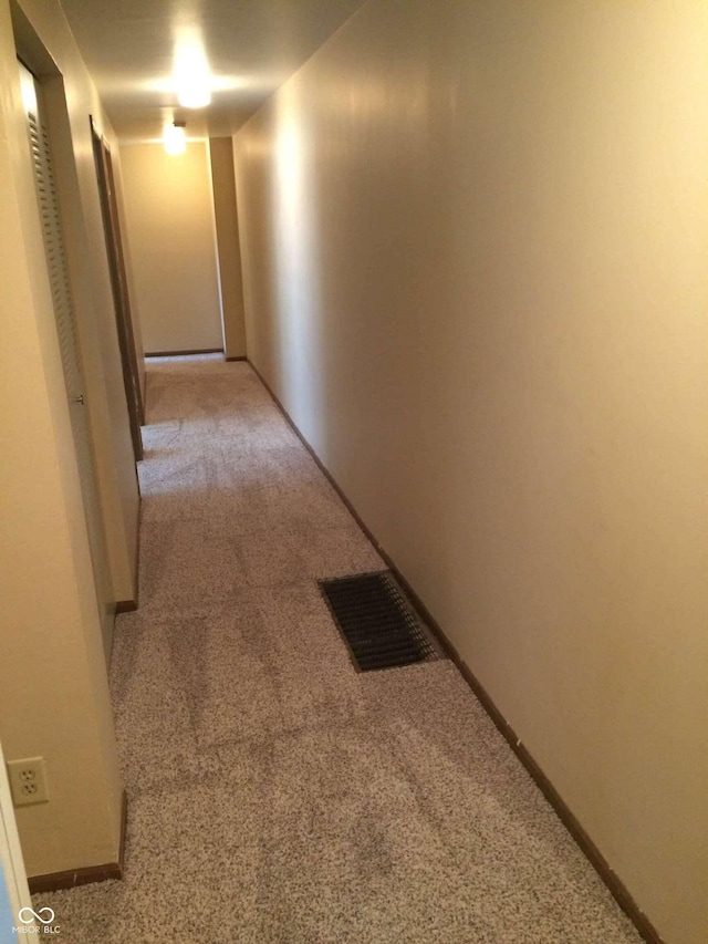 hallway featuring light colored carpet