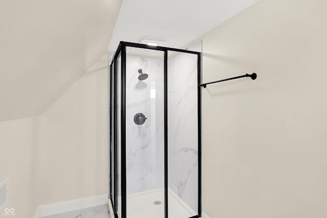 bathroom featuring vaulted ceiling and a shower with door