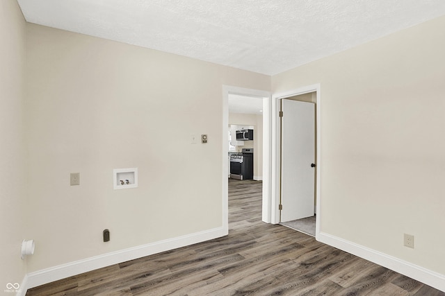 laundry room featuring hookup for a washing machine, wood-type flooring, and a textured ceiling