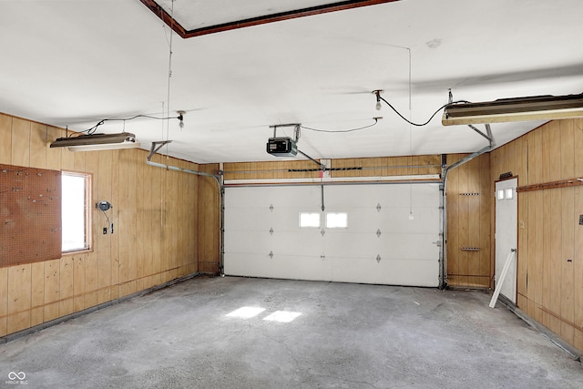 garage with a garage door opener and wood walls