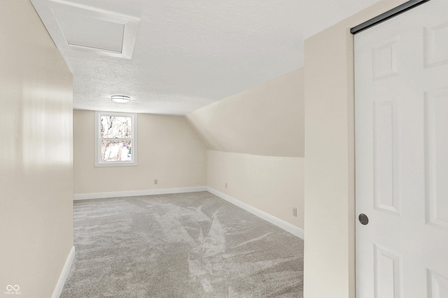 additional living space featuring light carpet, lofted ceiling, and a textured ceiling