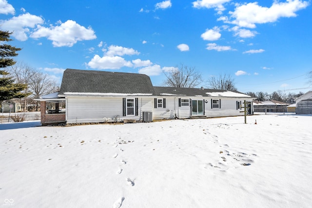 snow covered house featuring cooling unit