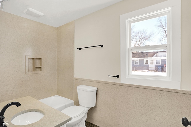 bathroom featuring vanity, tile walls, and toilet