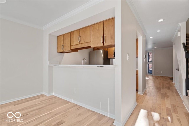 kitchen featuring crown molding, stainless steel fridge, and light wood-type flooring