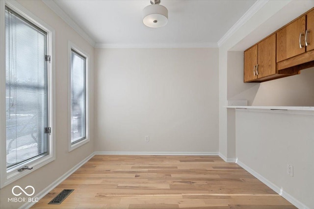 unfurnished dining area with ornamental molding and light hardwood / wood-style floors