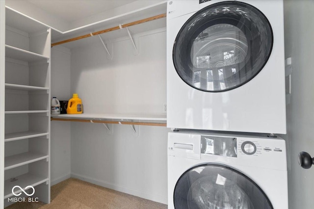 laundry area with stacked washer and dryer and light carpet