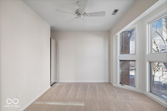 spare room featuring ceiling fan and light colored carpet