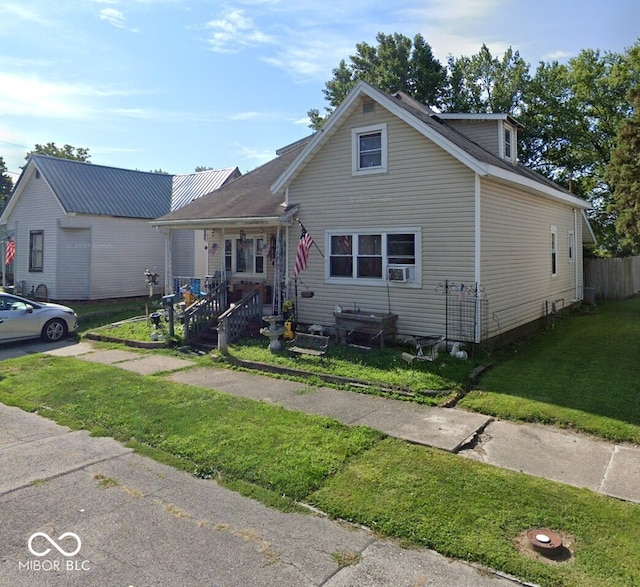 view of front of home featuring cooling unit, a porch, and a front yard