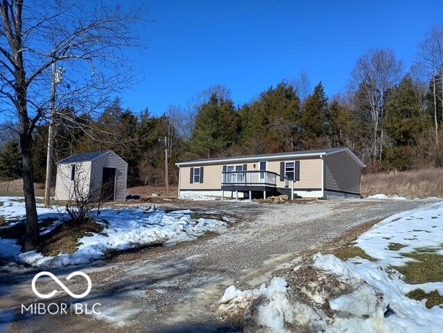 manufactured / mobile home featuring a wooden deck and a shed