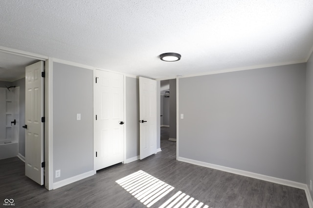 unfurnished bedroom featuring a closet, dark hardwood / wood-style floors, and a textured ceiling