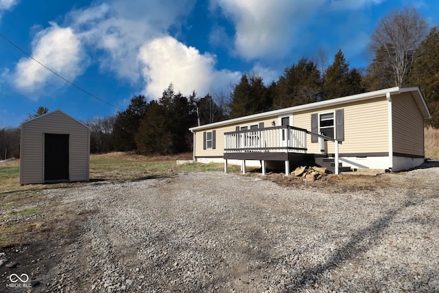 view of front of home with a wooden deck and a storage unit