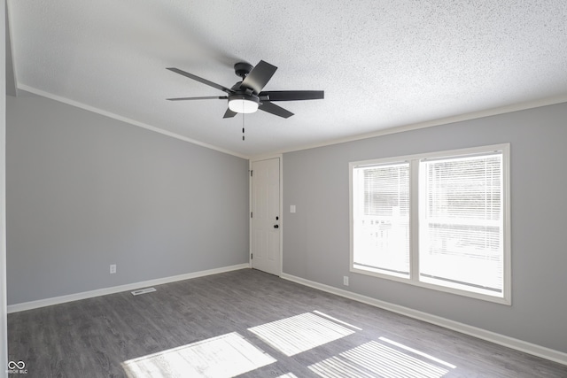 empty room featuring ceiling fan, ornamental molding, dark hardwood / wood-style floors, and a textured ceiling