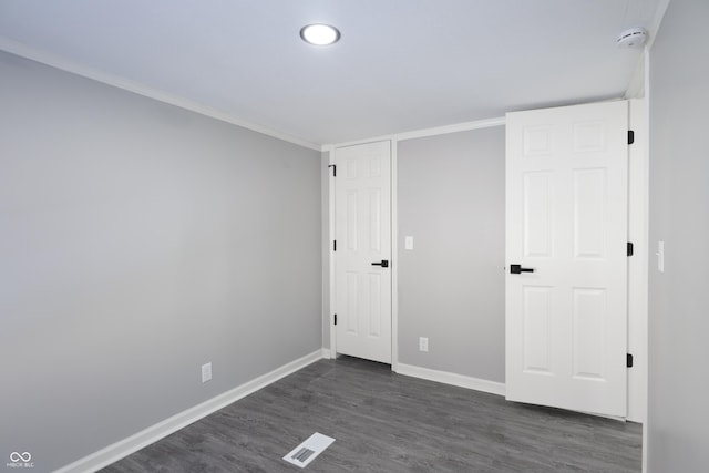 unfurnished bedroom featuring crown molding and dark hardwood / wood-style flooring