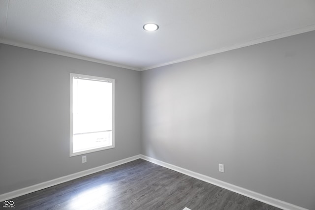 spare room featuring dark wood-type flooring and ornamental molding