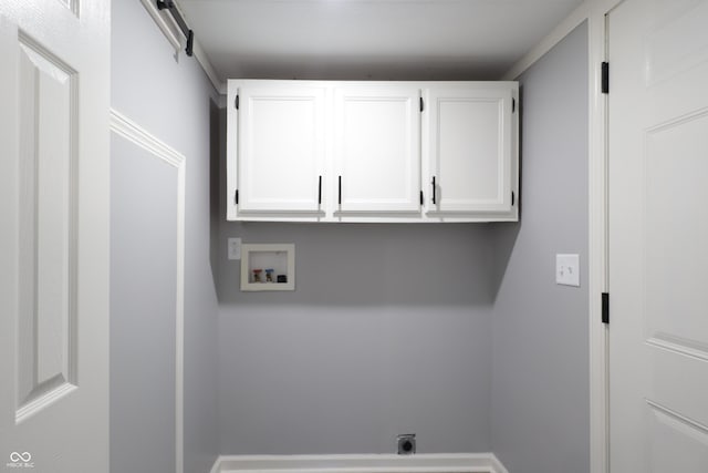 washroom with washer hookup, cabinets, electric dryer hookup, and a barn door