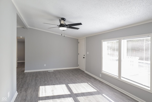 empty room with dark wood-type flooring, ceiling fan, lofted ceiling with beams, and a textured ceiling