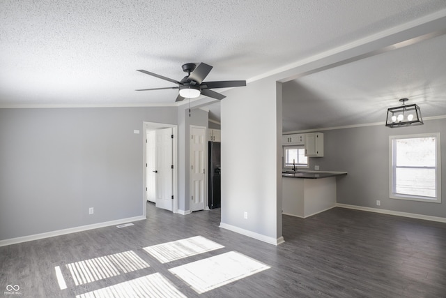 unfurnished living room with ornamental molding, dark hardwood / wood-style flooring, and a textured ceiling