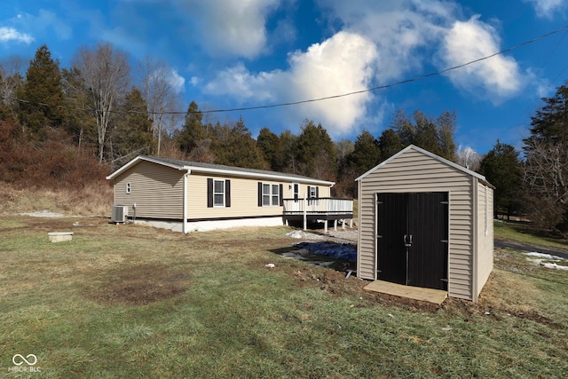 view of outdoor structure featuring a yard and central AC