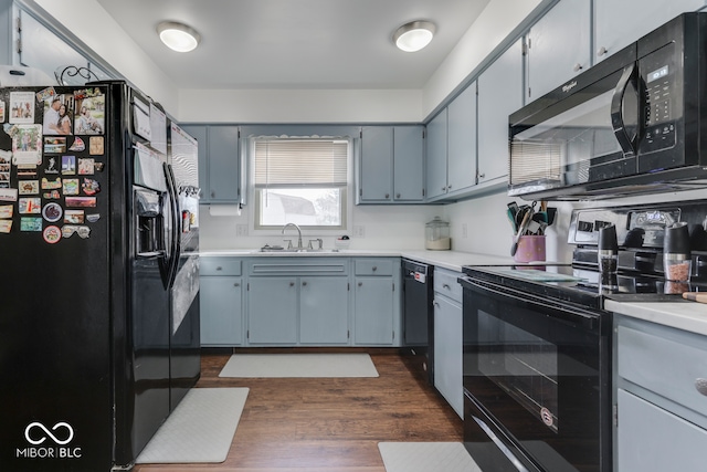 kitchen featuring sink, dark wood-type flooring, and black appliances