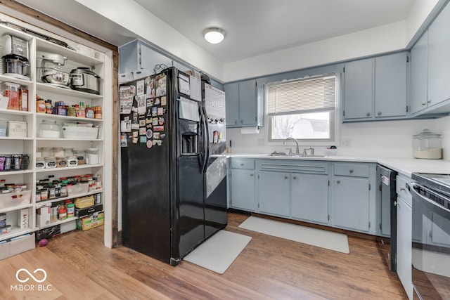 kitchen with sink, black refrigerator with ice dispenser, light wood-type flooring, white electric stove, and dishwasher