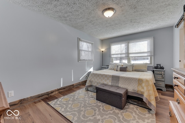 bedroom with wood-type flooring and a textured ceiling