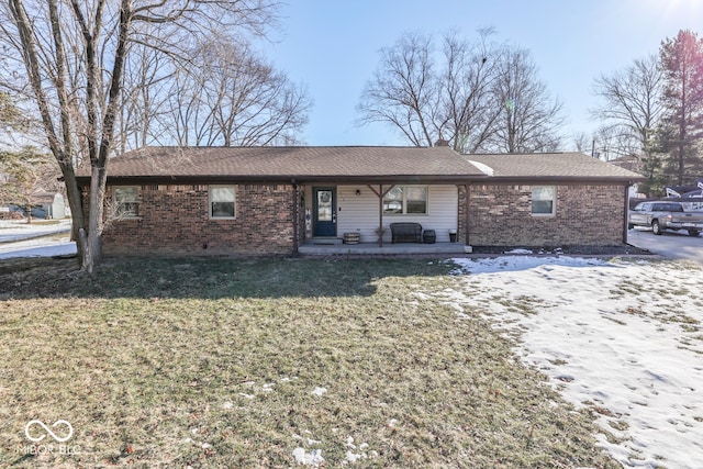 ranch-style house with covered porch and a front lawn