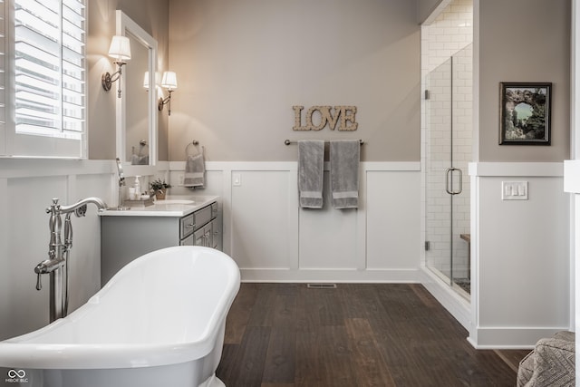 bathroom with wood-type flooring, separate shower and tub, and vanity