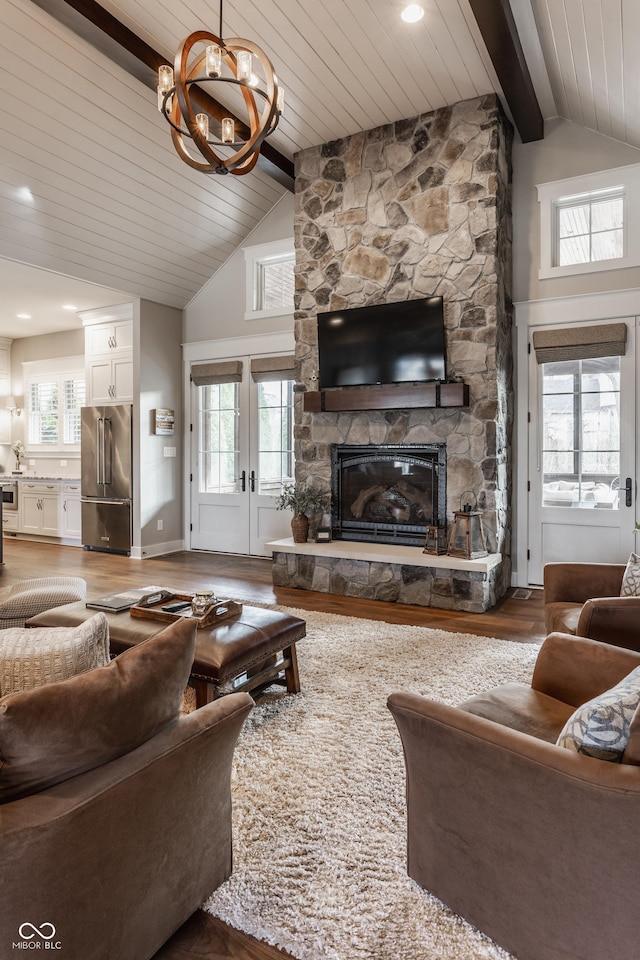 living room with a fireplace, hardwood / wood-style flooring, plenty of natural light, and beamed ceiling