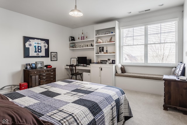 carpeted bedroom with built in desk