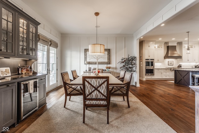 dining room with beverage cooler and dark hardwood / wood-style flooring