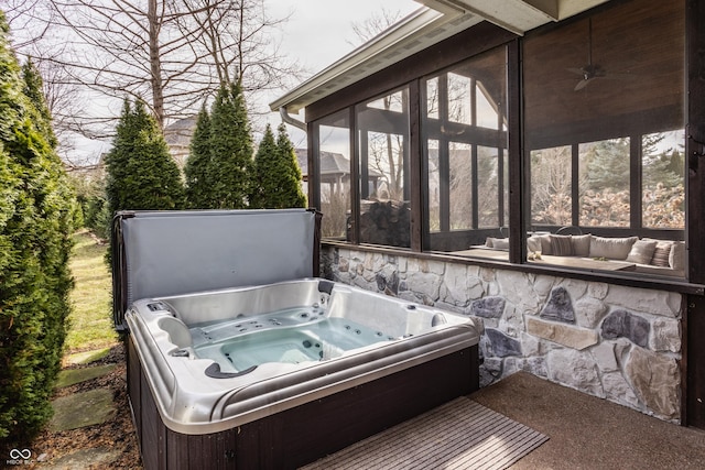 view of patio / terrace with a sunroom and a hot tub