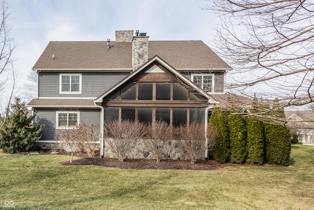 rear view of property with a sunroom and a yard