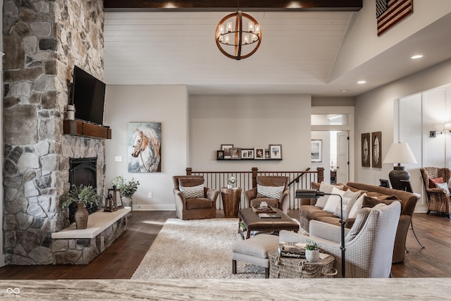 living room featuring dark hardwood / wood-style flooring, a stone fireplace, high vaulted ceiling, and a chandelier