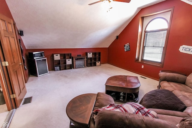 carpeted living room featuring ceiling fan, lofted ceiling, and a textured ceiling