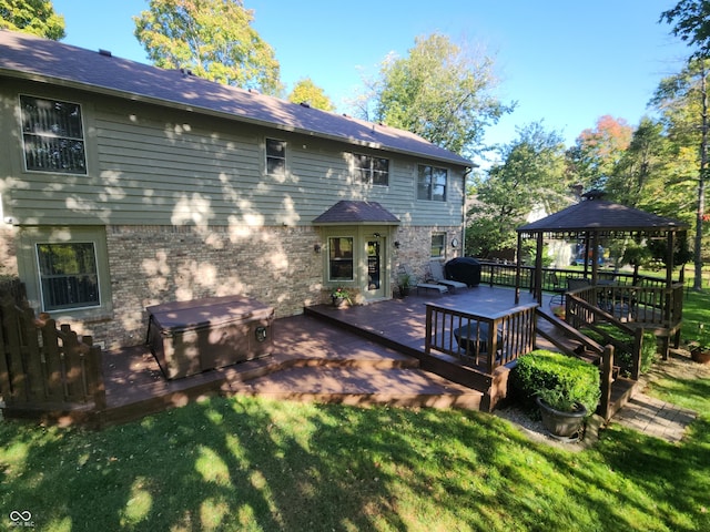 back of house featuring a gazebo, a deck, and a lawn