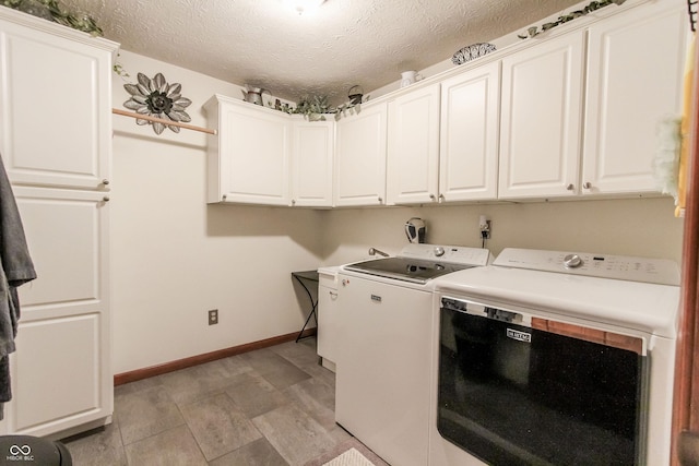 laundry area featuring washing machine and dryer, cabinets, and a textured ceiling