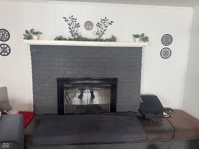 interior details featuring a brick fireplace and crown molding