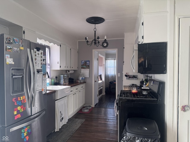 kitchen with appliances with stainless steel finishes, sink, white cabinets, a chandelier, and dark wood-type flooring