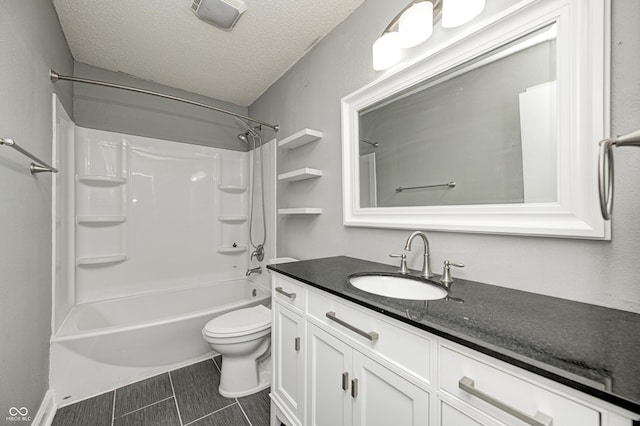 full bathroom featuring toilet, vanity, a textured ceiling, and  shower combination