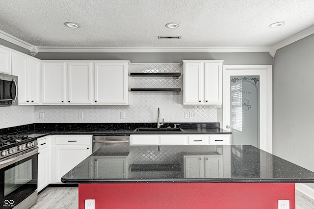 kitchen featuring appliances with stainless steel finishes, sink, a kitchen island, and dark stone counters