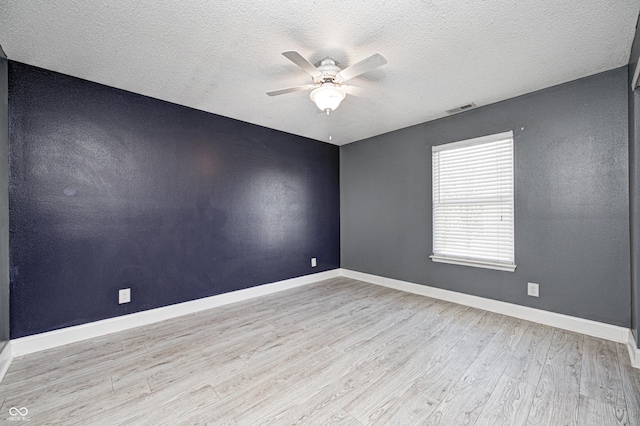 spare room with a textured ceiling, light hardwood / wood-style flooring, and ceiling fan