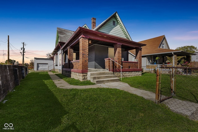 view of front of property featuring a garage, covered porch, and a lawn