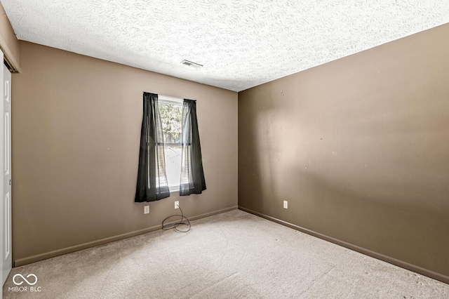 unfurnished room featuring carpet floors and a textured ceiling