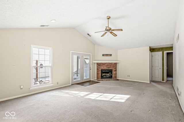 unfurnished living room with vaulted ceiling, light carpet, ceiling fan, and a fireplace