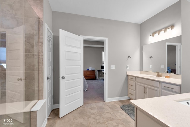 bathroom featuring a tile shower, vanity, and tile patterned flooring