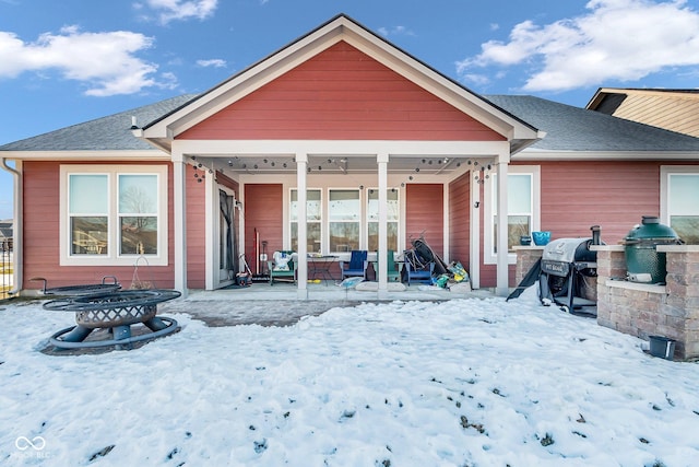 view of snow covered back of property