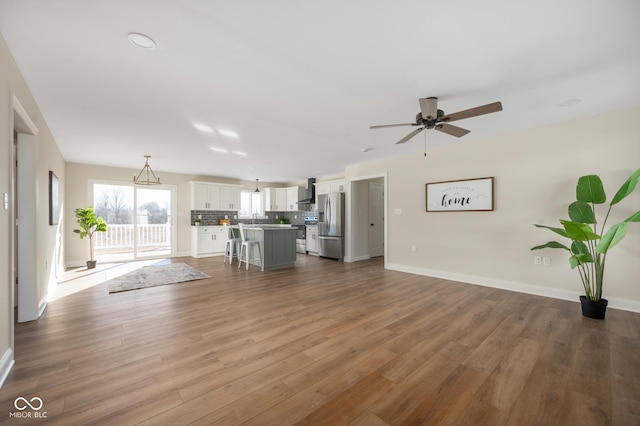 unfurnished living room featuring hardwood / wood-style flooring and ceiling fan